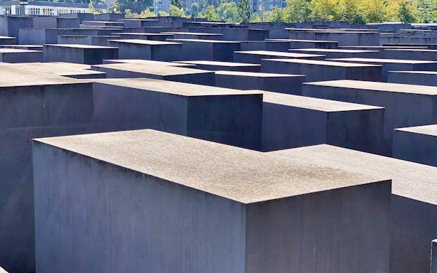 Holocaust Memorial in Berlin with concrete slabs under a clear sky.