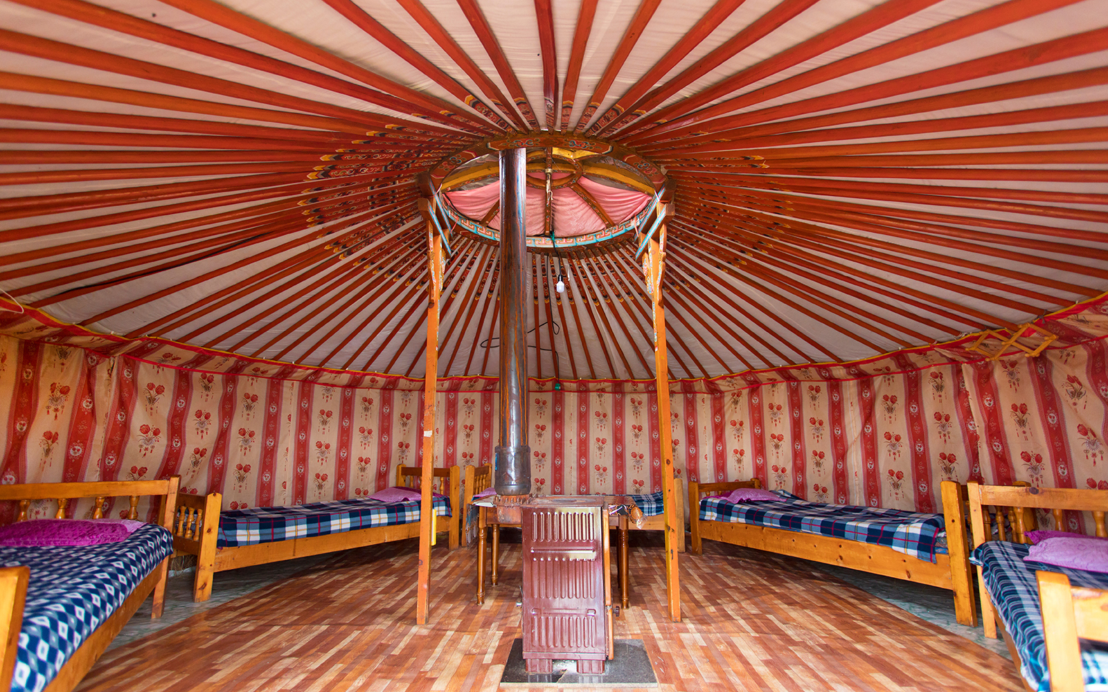 Wool lined walls of a yurt, filled with matresses placed in a circular fashion