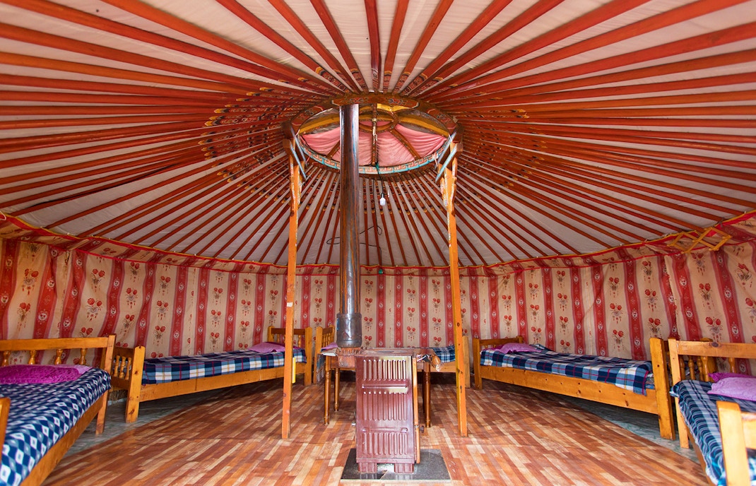 Wool lined walls of a yurt, filled with matresses placed in a circular fashion