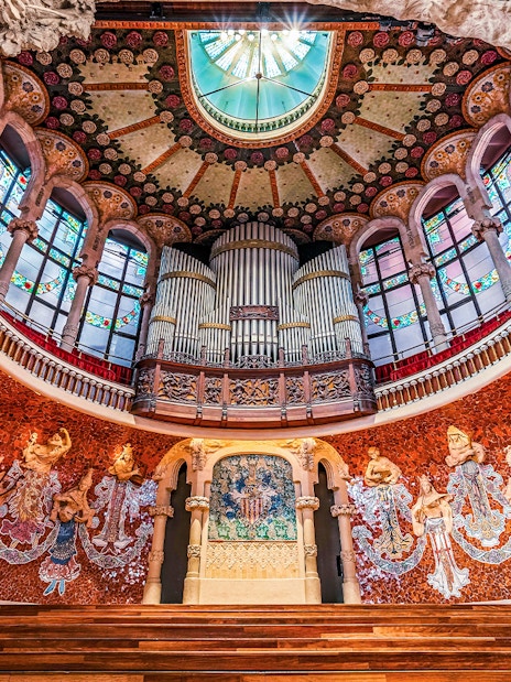 Wooden stage with stone relief and ornate organ inside Palau de la Musica Catalana, Barcelona.