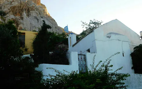 Plaka neighborhood with traditional houses and Greek flag, Athens exploration game.
