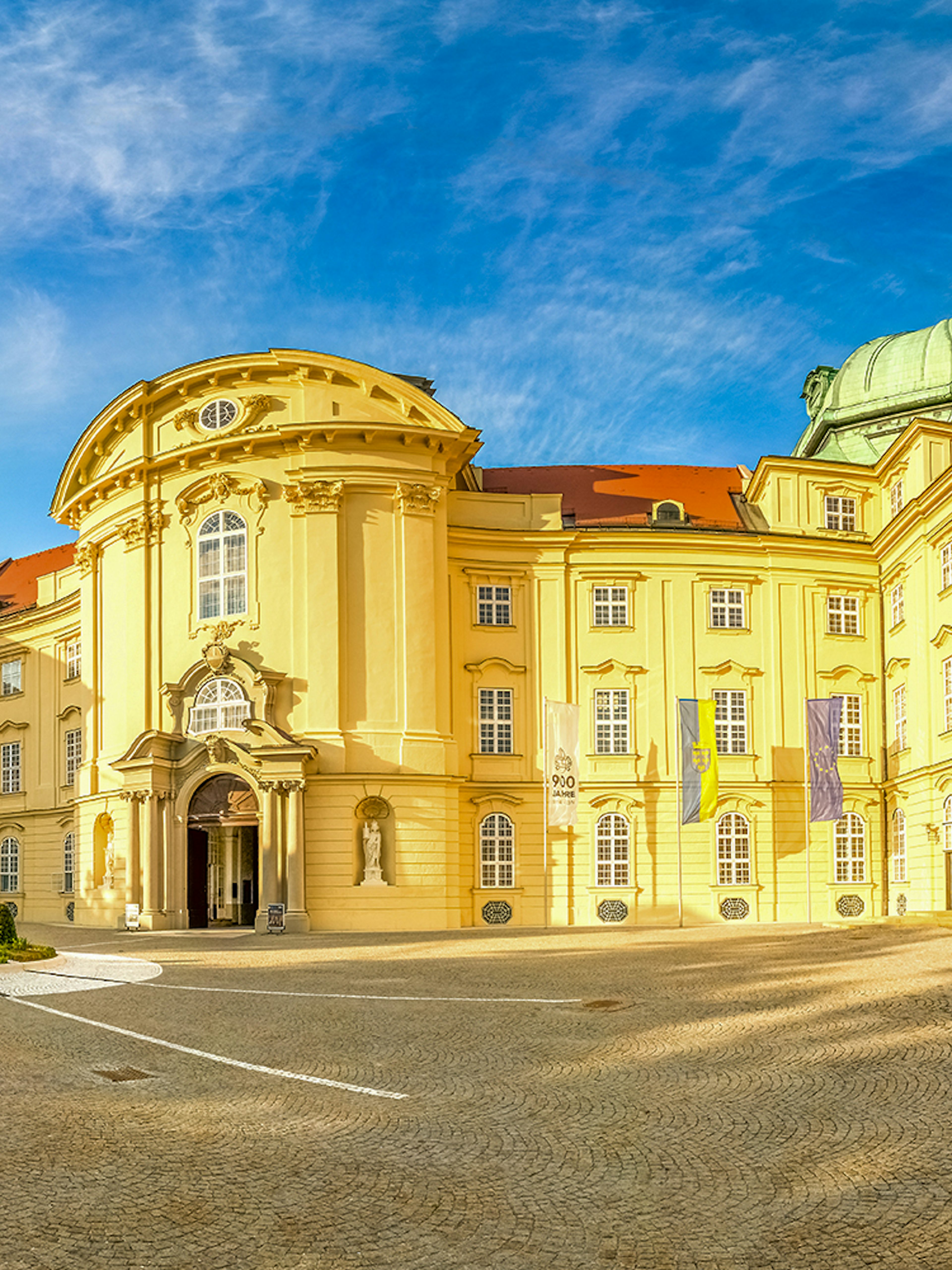 Klosterneuburg Monastery exterior with twin spires under a blue sky, Austria.