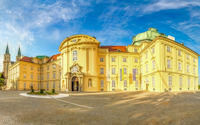 Klosterneuburg Monastery exterior with twin spires under a blue sky, Austria.