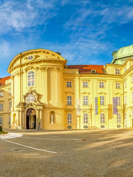 Klosterneuburg Monastery exterior with twin spires under a blue sky, Austria.