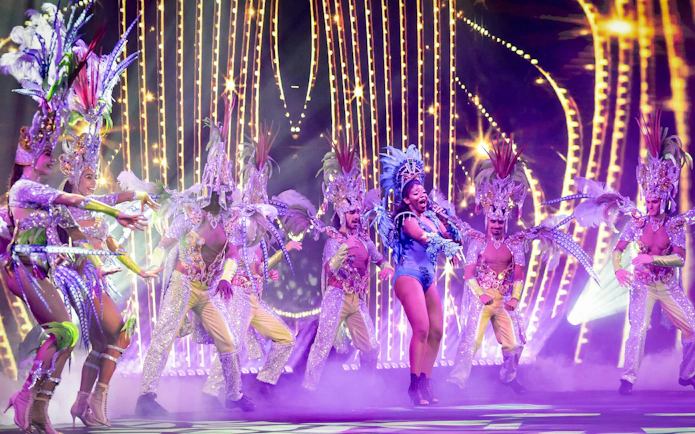 Performers in vibrant costumes on stage at Sala Scala, Gran Canaria.