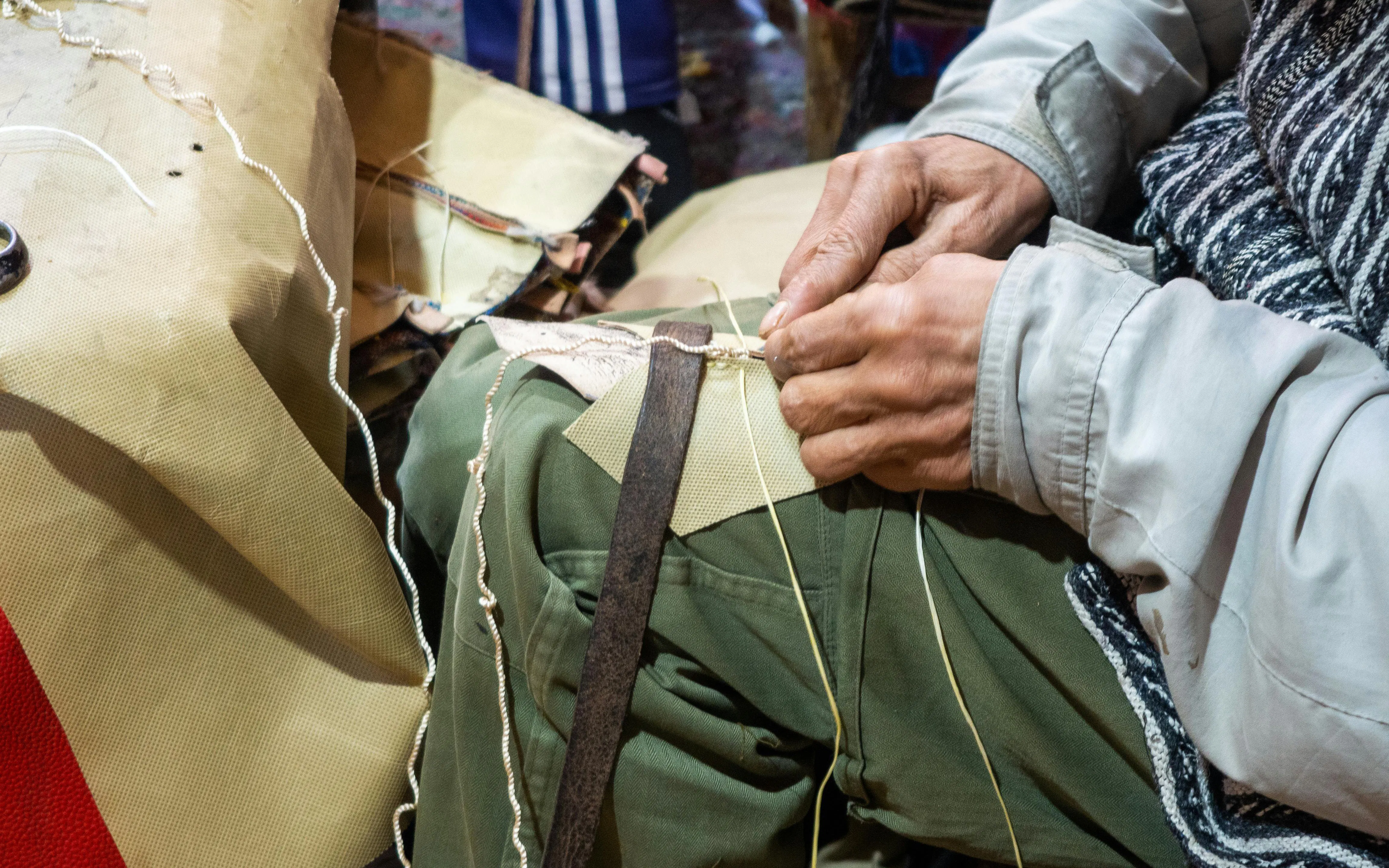 Craftsman stitching slippers in a Marrakech workshop.