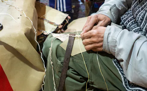 Craftsman stitching slippers in a Marrakech workshop.