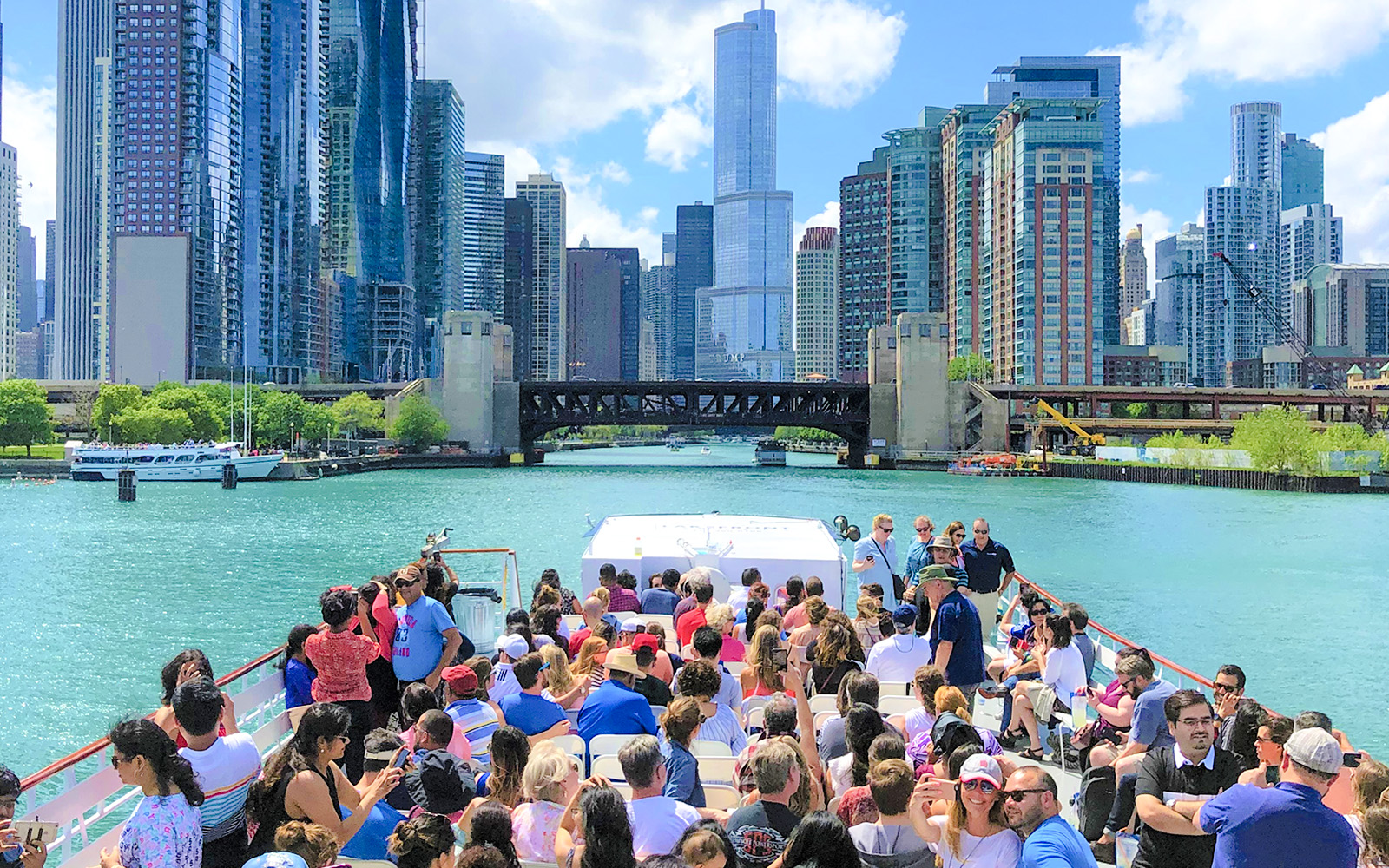 Chicago River cruise with tourists viewing skyline and architecture.