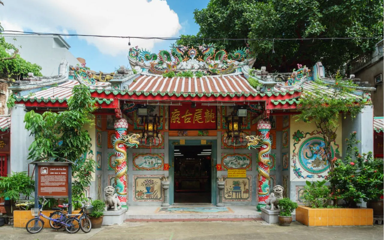 Colorful Chinese temple entrance in Bangkok's Chinatown with intricate dragon carvings.