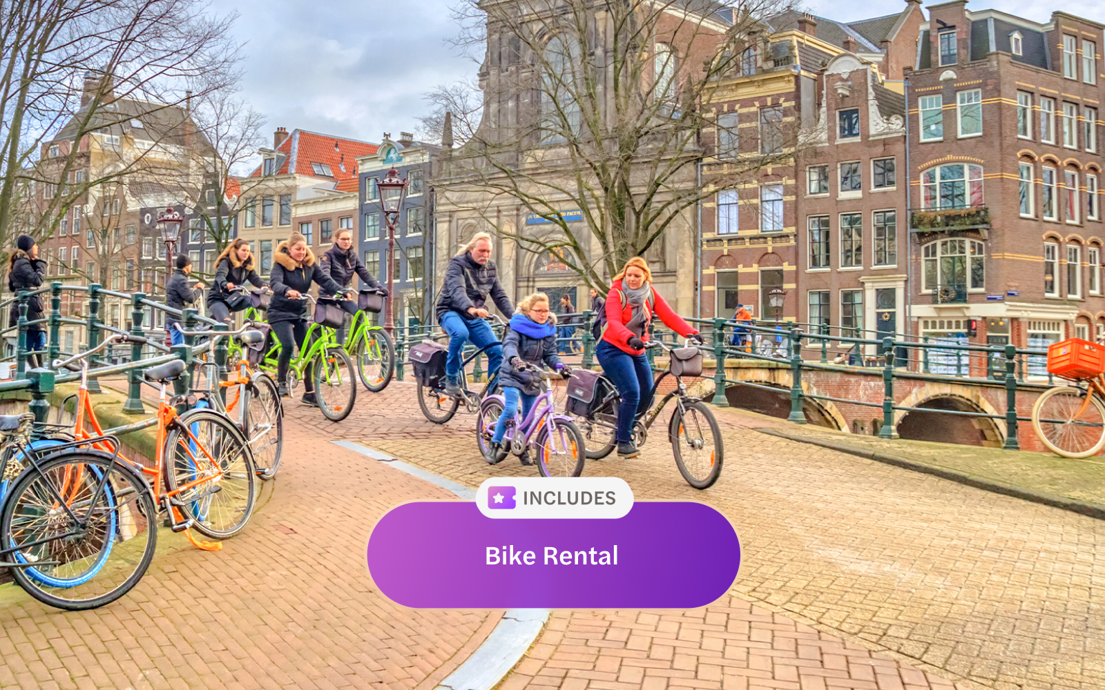 Cyclists riding on an Amsterdam canal bridge with historic buildings in the background.