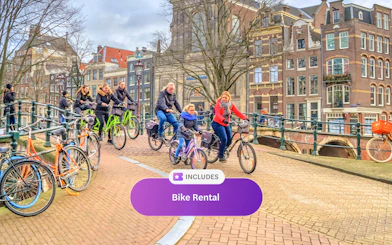 Cyclists riding on an Amsterdam canal bridge with historic buildings in the background.