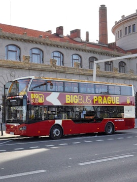 Double-decker Big Bus Prague tour bus parked in front of historic building.