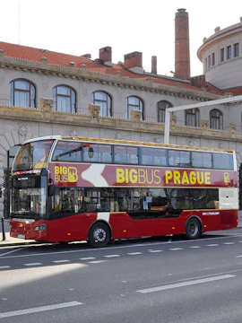 Double-decker Big Bus Prague tour bus parked in front of historic building.