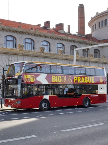 Double-decker Big Bus Prague tour bus parked in front of historic building.