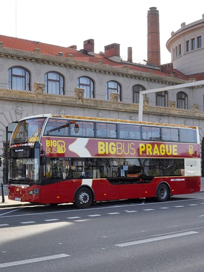 Double-decker Big Bus Prague tour bus parked in front of historic building.