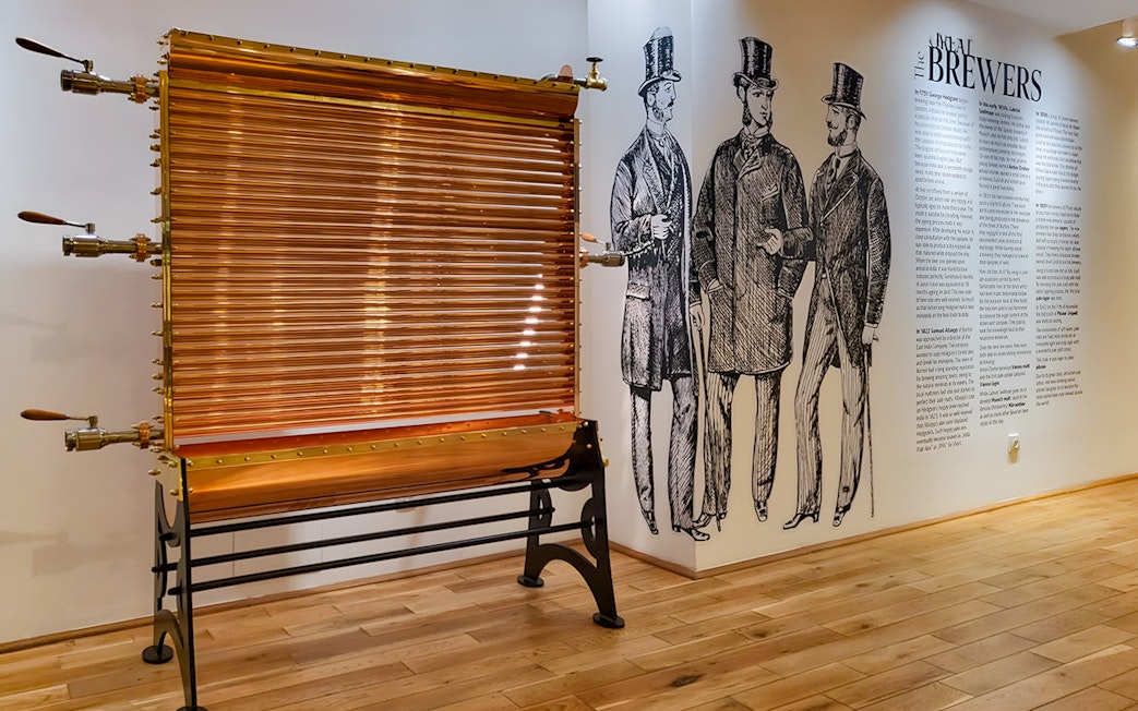 Copper brewing equipment and historical brewer illustrations inside Prague Beer Museum.