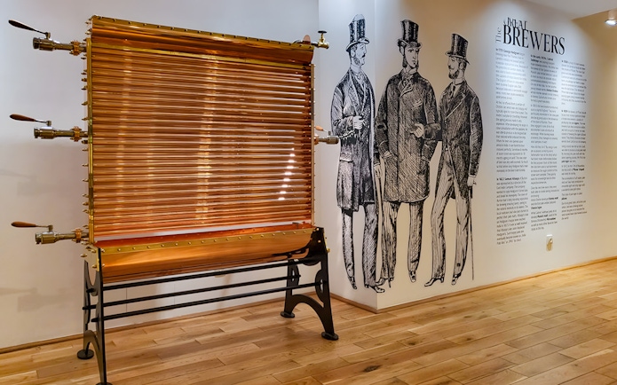 Copper brewing equipment and historical brewer illustrations inside Prague Beer Museum.