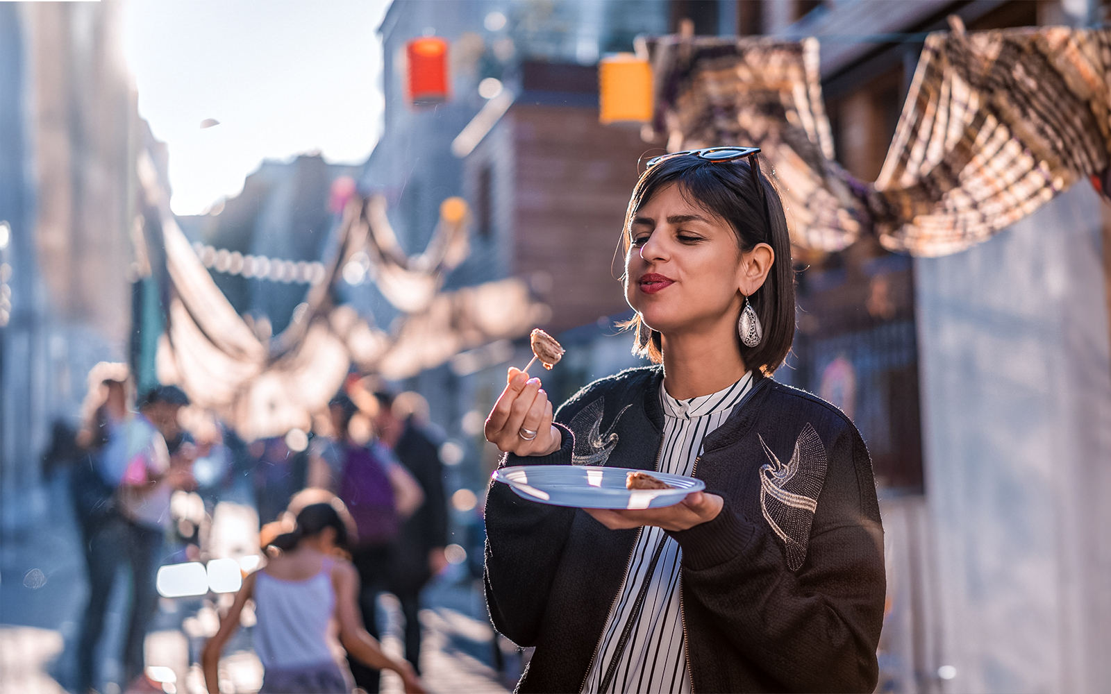 Person enjoying food on a street in Montmartre, Paris during a food tour.