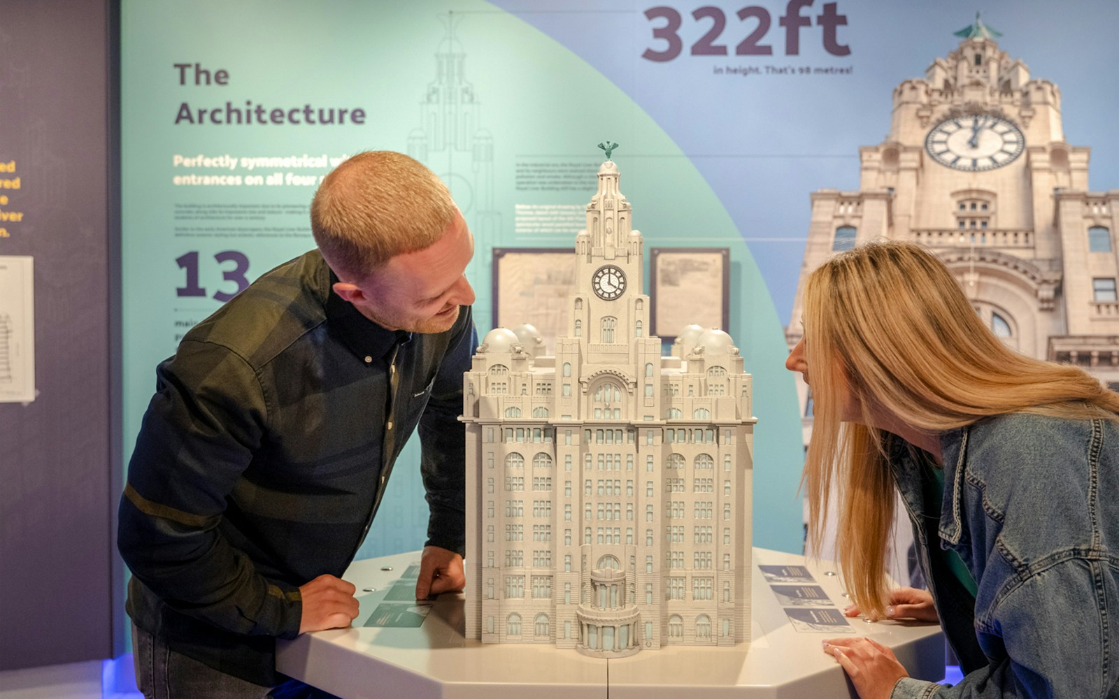 Visitors examining a model of the Royal Liver Building inside the exhibit.