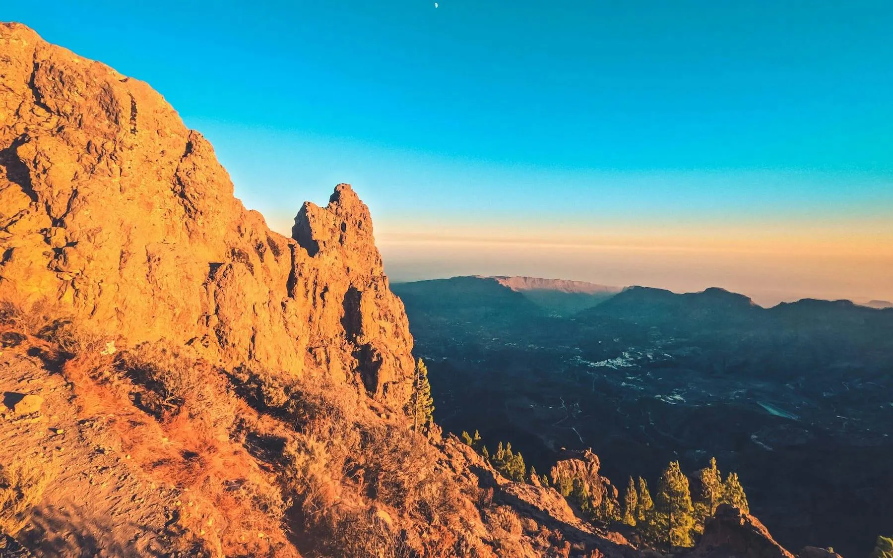 Gran Canaria volcanic landscape at sunset with distant mountains.