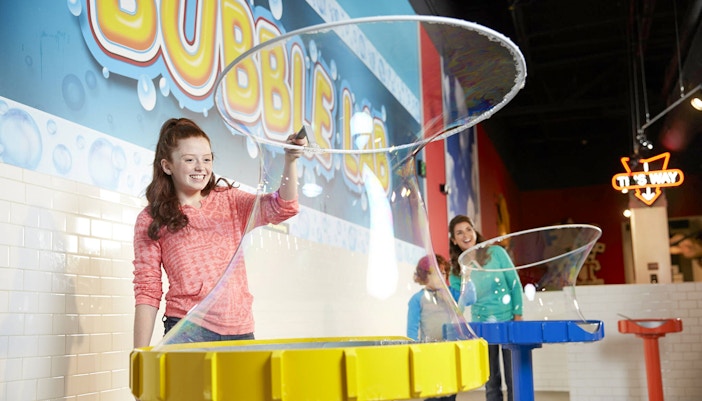 Guests playing inside Bubble lab at A man playing laser tag inside WonderWorks Orlando
