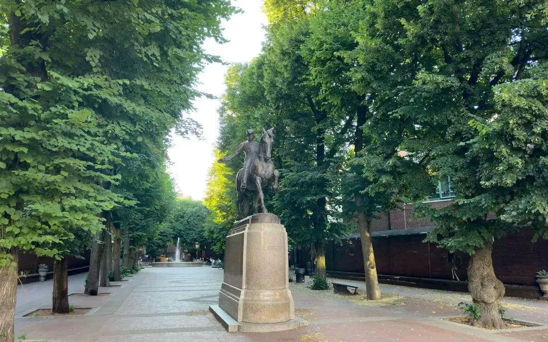 Statue of a historical figure on horseback along a tree-lined path in Boston's Greenway.