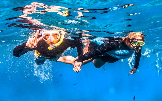Snorkelers exploring underwater during Molokini & Turtle Adventure Raft tour, Maui, Hawaii.