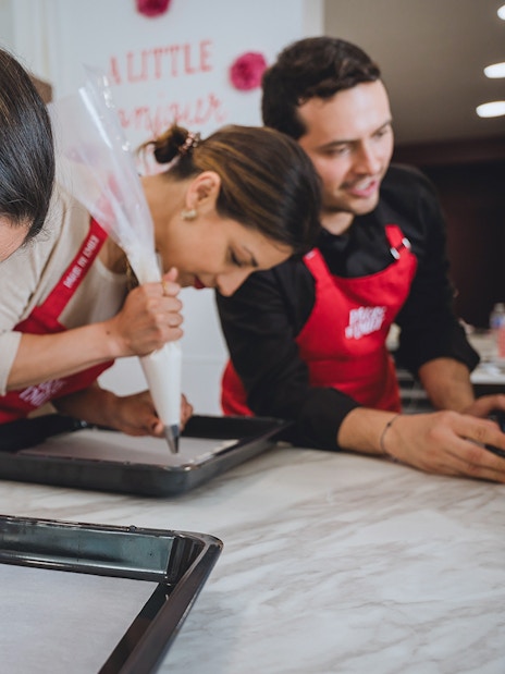 Lady piping macarons in Emily in Paris Macaron-Making Workshop.