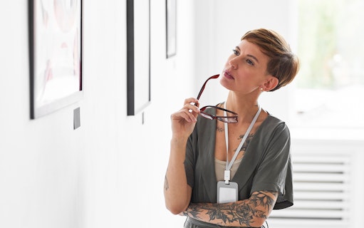 Visitor observing artwork at Fondation Louis Vuitton's Matisse: The Red Studio exhibit.