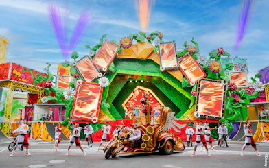 Colorful parade with performers and floats at Disneyland Paris.