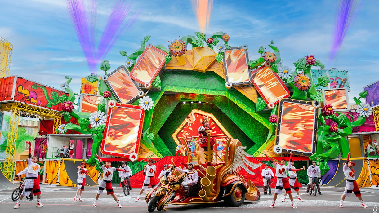 Colorful parade with performers and floats at Disneyland Paris.