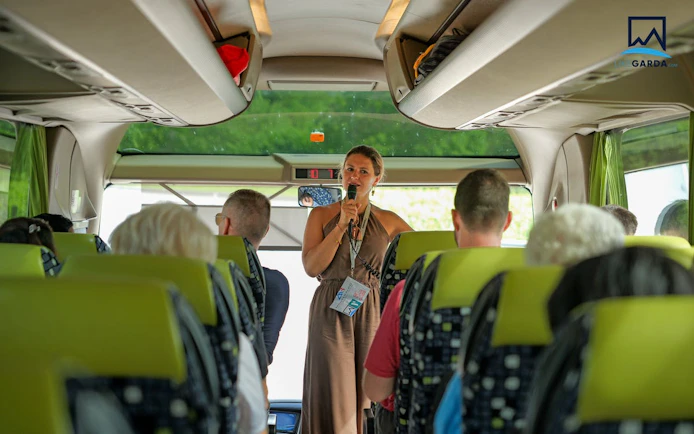Tour guide speaking to passengers on a bus during Dolomites tour from Verona.