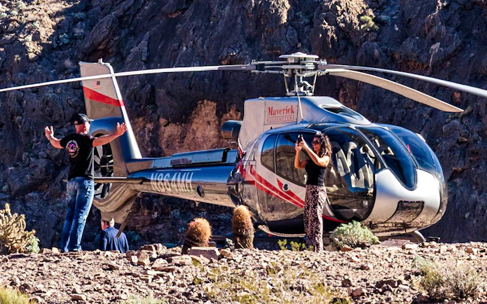 Helicopter landed at Grand Canyon West with tourists taking photos.