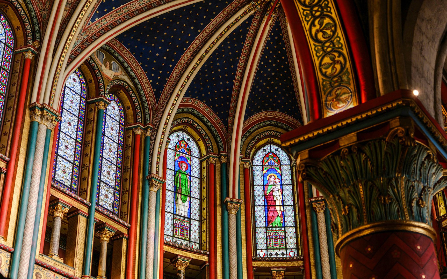 Stained glass windows and ornate arches inside Sainte-Chapelle, Paris.