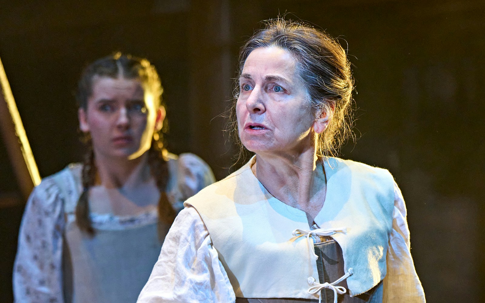 Actors performing a scene from the play "Hamnet" on stage.