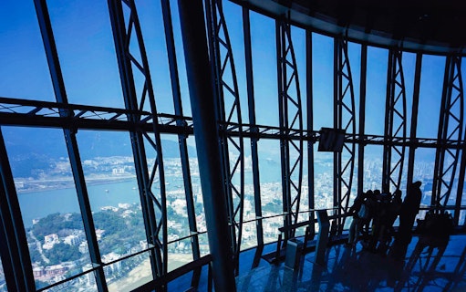View from Macau Tower observation deck overlooking city and harbor.