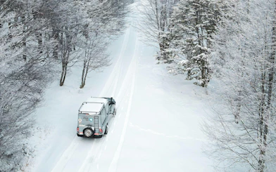4x4 vehicle driving through snowy forest on Lakes Escondido and Fagnano tour.