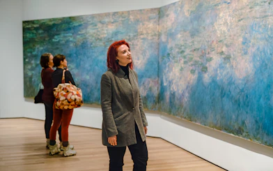 Visitor admiring Monet painting at MoMA in New York City.