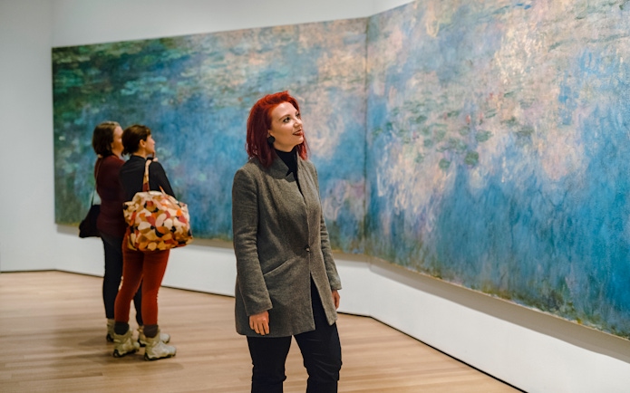 Visitor admiring Monet painting at MoMA in New York City.