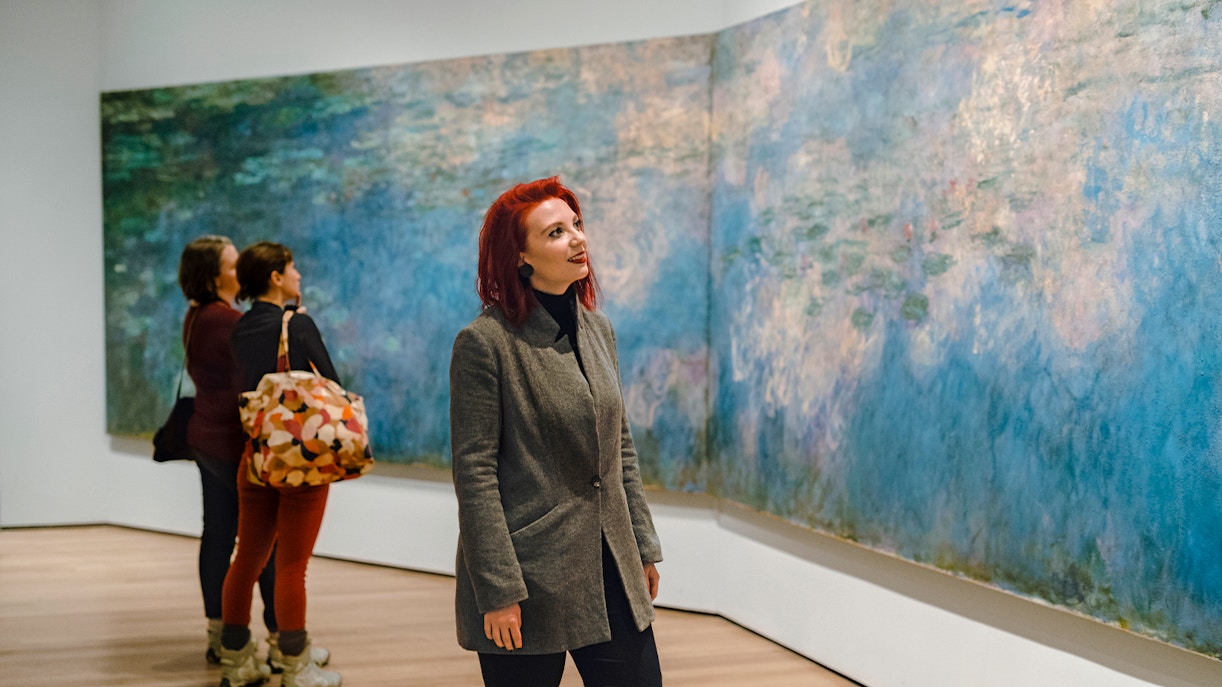 Visitor admiring Monet painting at MoMA in New York City.