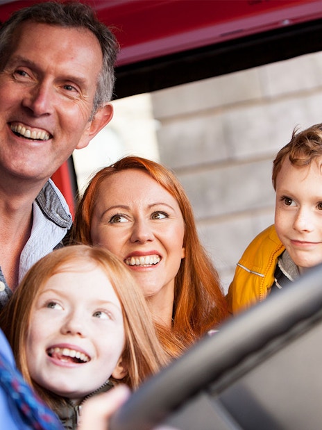 Family enjoying City Sightseeing Hop-On Hop-Off bus tour in Edinburgh.
