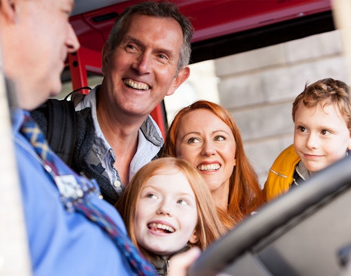 A family of four, consisting of mother, father and two children boarding a hop on hop off bus