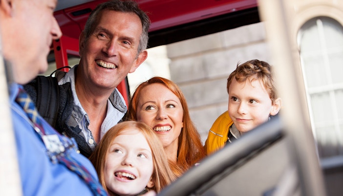 Una familia de cuatro miembros, compuesta por madre, padre y dos hijos, sube a un bus turistico cartagena
