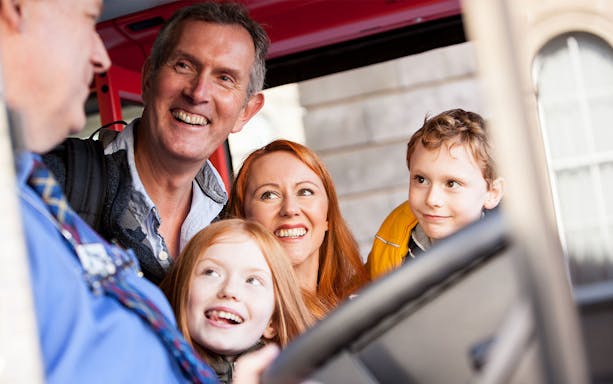Family enjoying City Sightseeing Hop-On Hop-Off bus tour in Edinburgh.