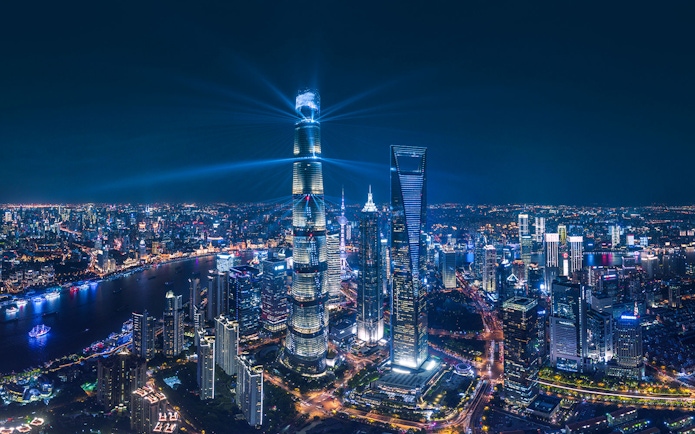 Panoramic night view of Shanghai skyline with illuminated skyscrapers from Shanghai Tower.