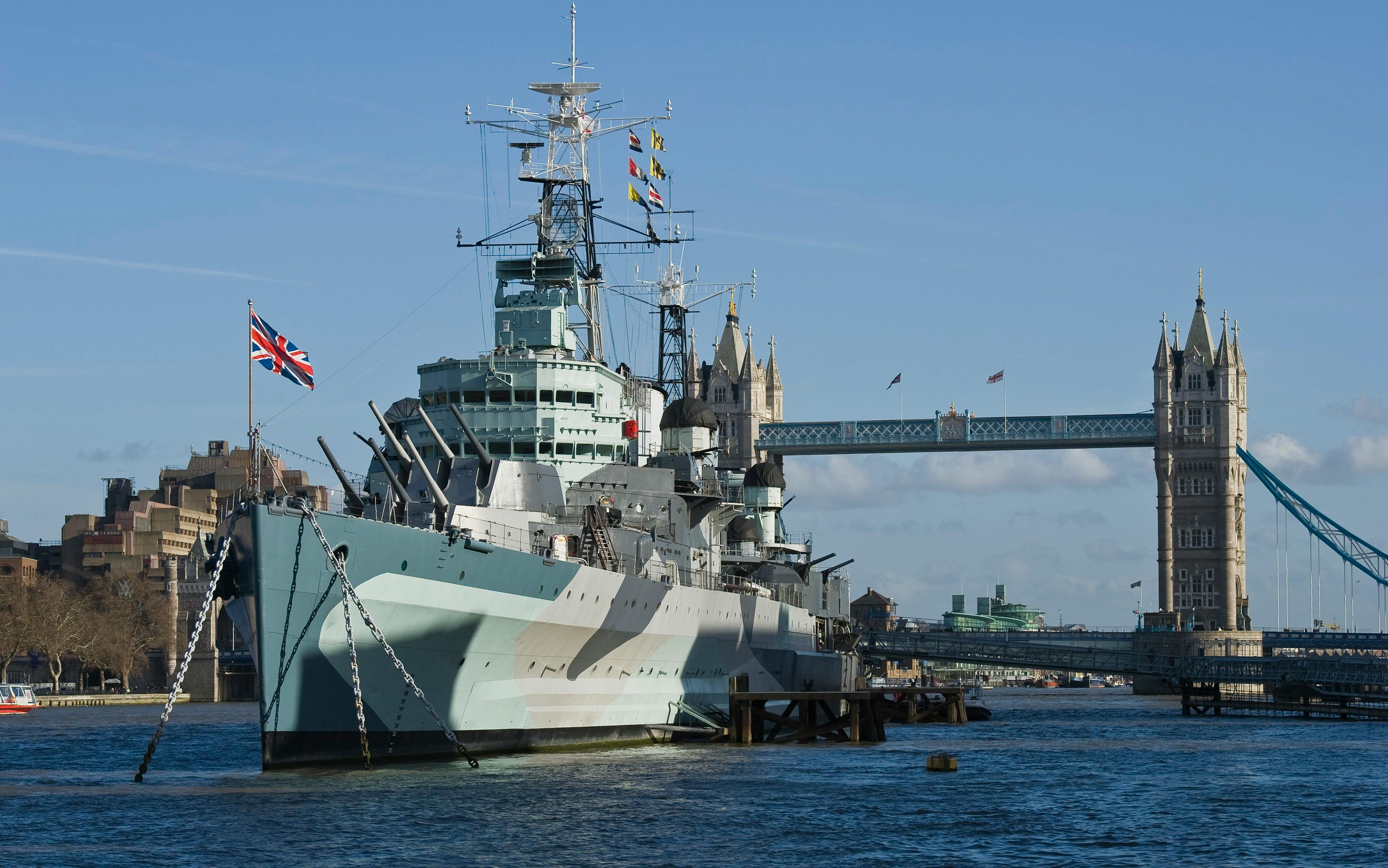 HMS Belfast moored on the River Thames with Tower Bridge in the background, London.