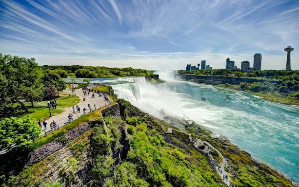 Visitors walking along the path overlooking Niagara Falls in Niagara Falls State Park.