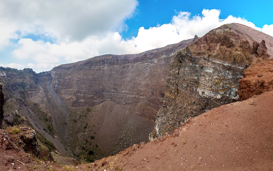 Crater of Mount Vesuvius in Naples, Italy, with rocky terrain and clear sky.