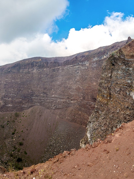 Crater of Mount Vesuvius in Naples, Italy, with rocky terrain and clear sky.
