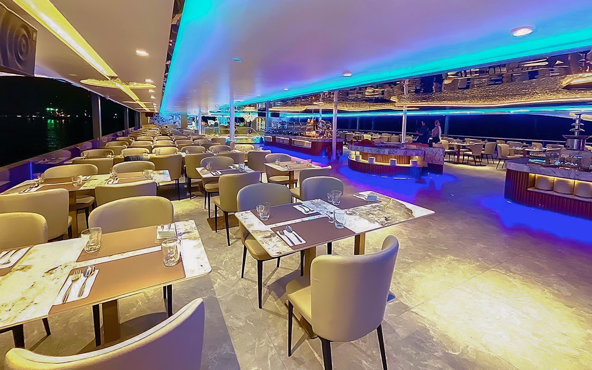 Elegant dining area on the Royal Galaxy Cruise with set tables and ambient lighting.